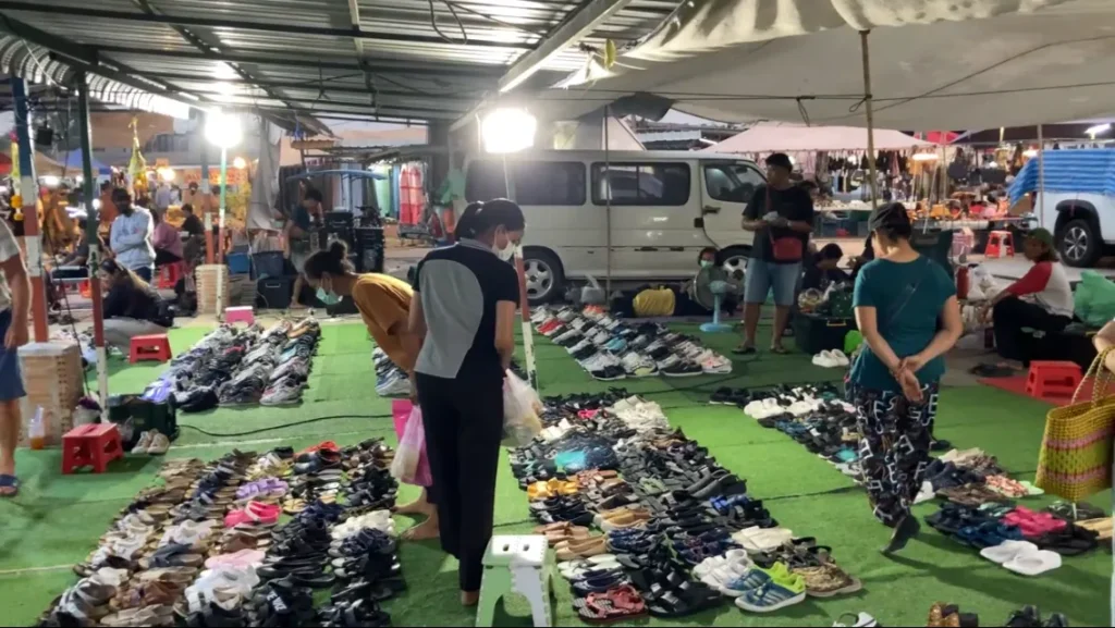 Skoförsäljare på natt marknaden i Klaeng Thailand